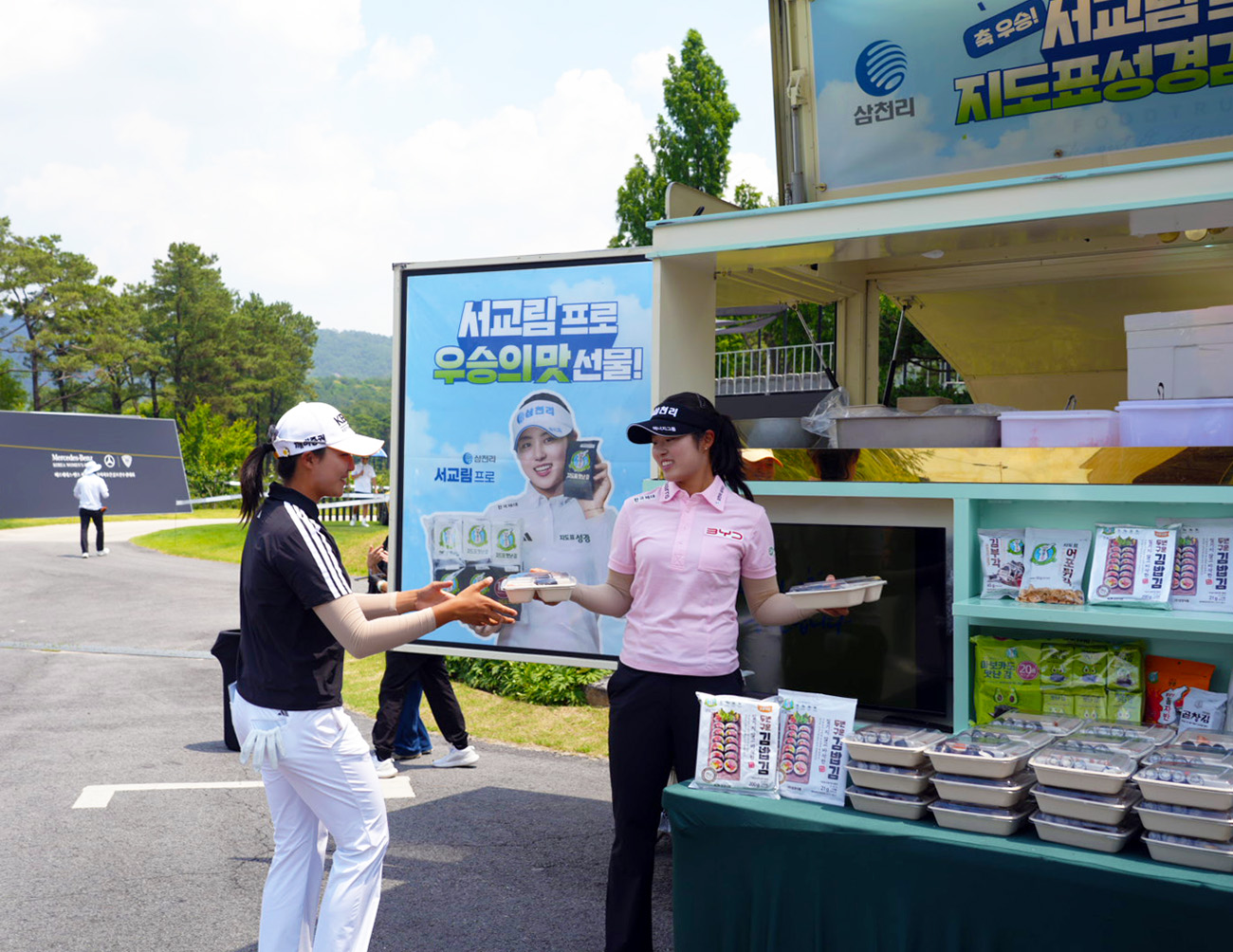 3. 삼천리 스포츠단 서교림 프로가 성경식품과 함께 마련한 푸드트럭에서 박예지 프로에게 먹거리를 선물하고 있다.jpg